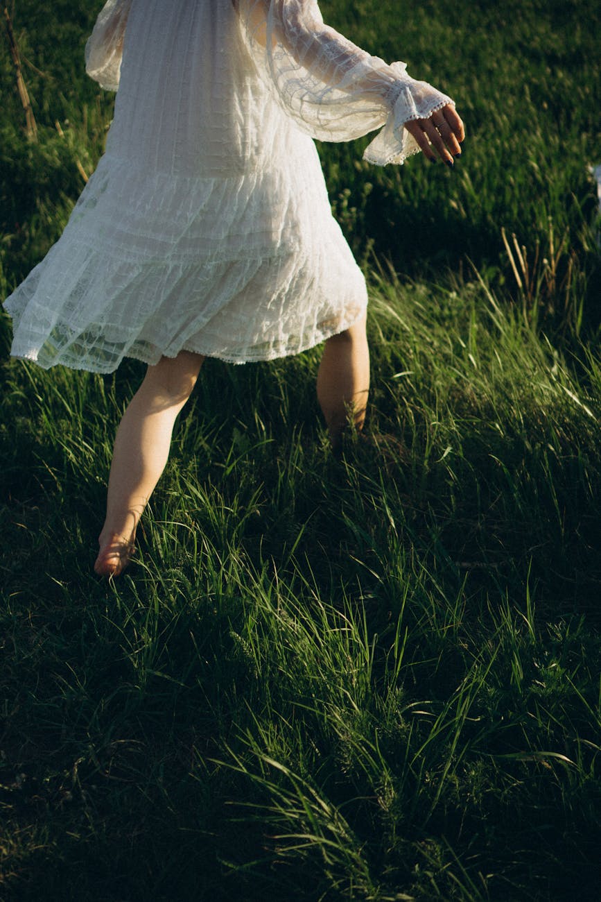 nervous system, woman in white lace dress walking through grass