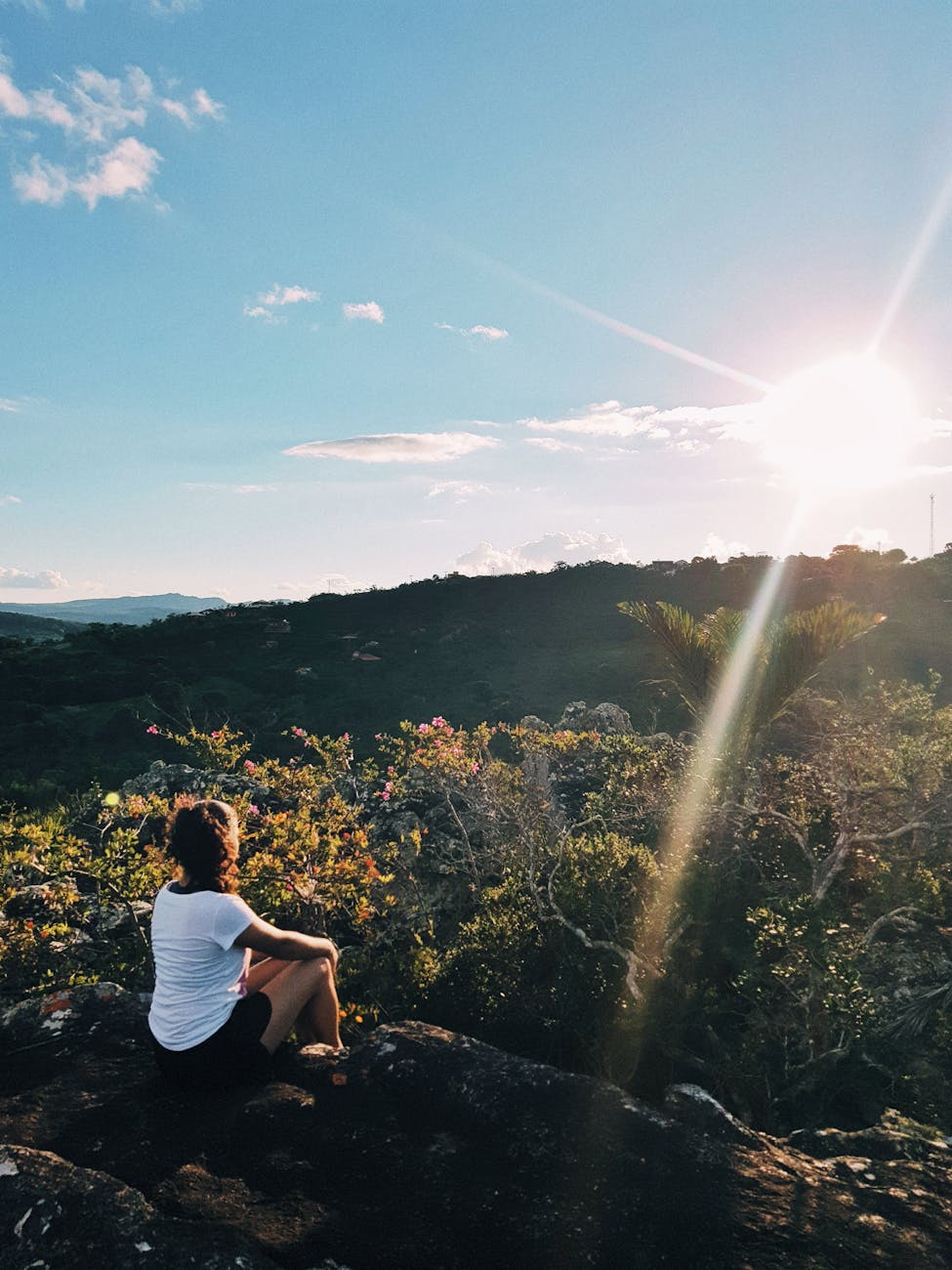photo of woman sitting on cliff. letting go