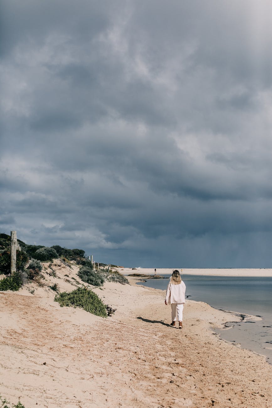anonymous female strolling on shore near water. rebirth