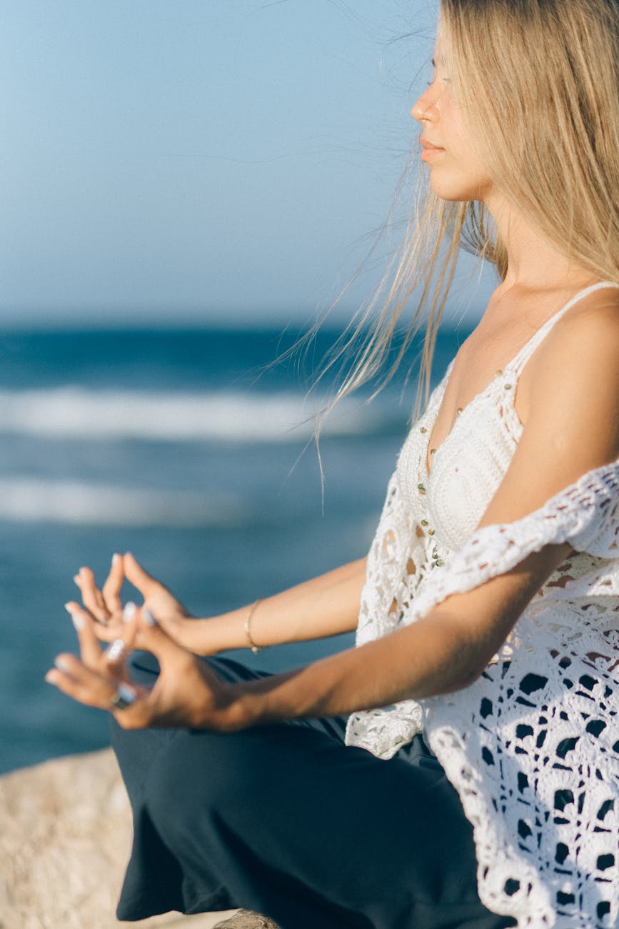 a woman meditating near sea. rituals
