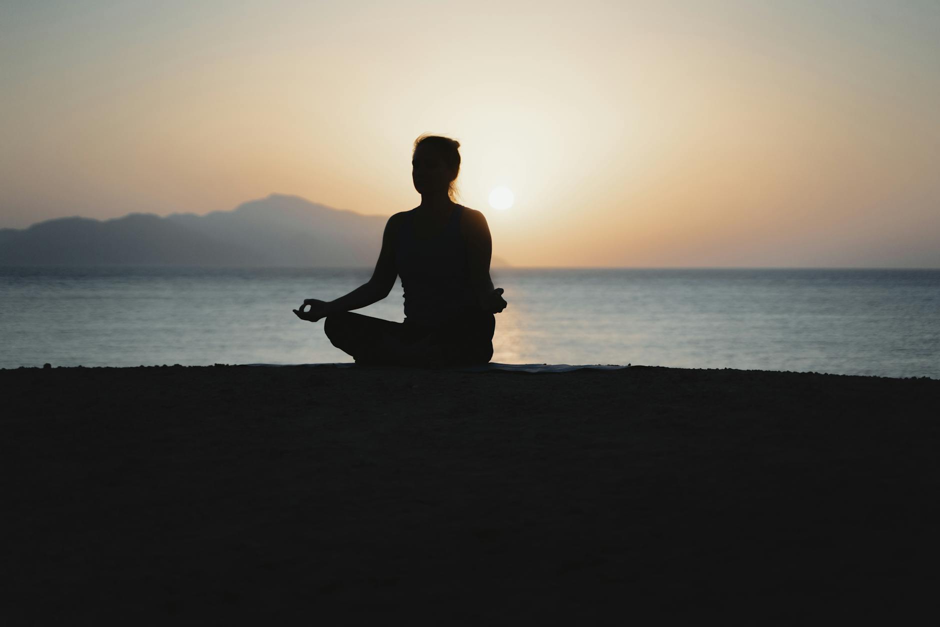 glow up,silhouette of woman doing yoga on the beach