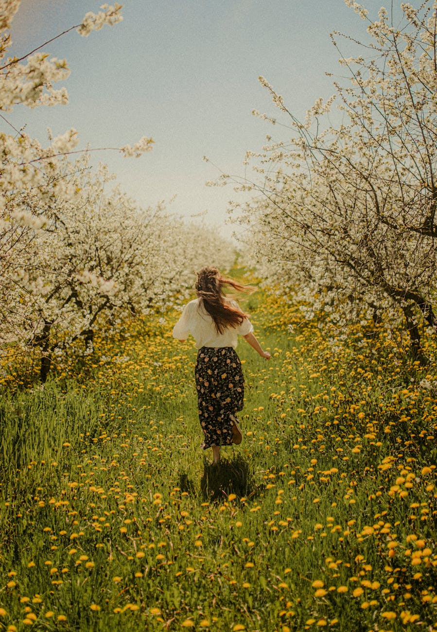 woman running in blossoming orchard. grace