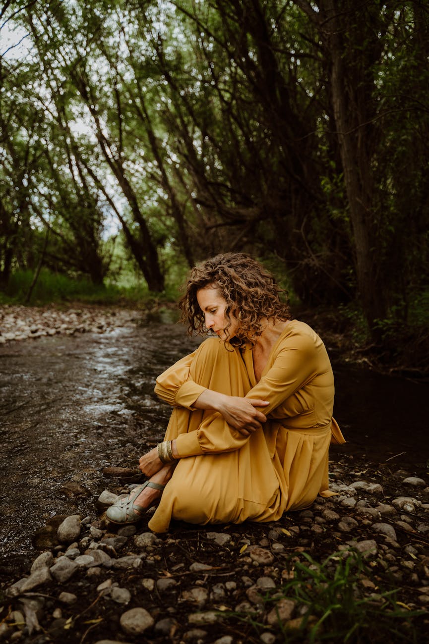 contemplative woman in nature by a stream. reinvention