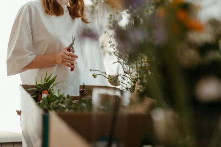 woman in white long sleeve shirt holding white flower
